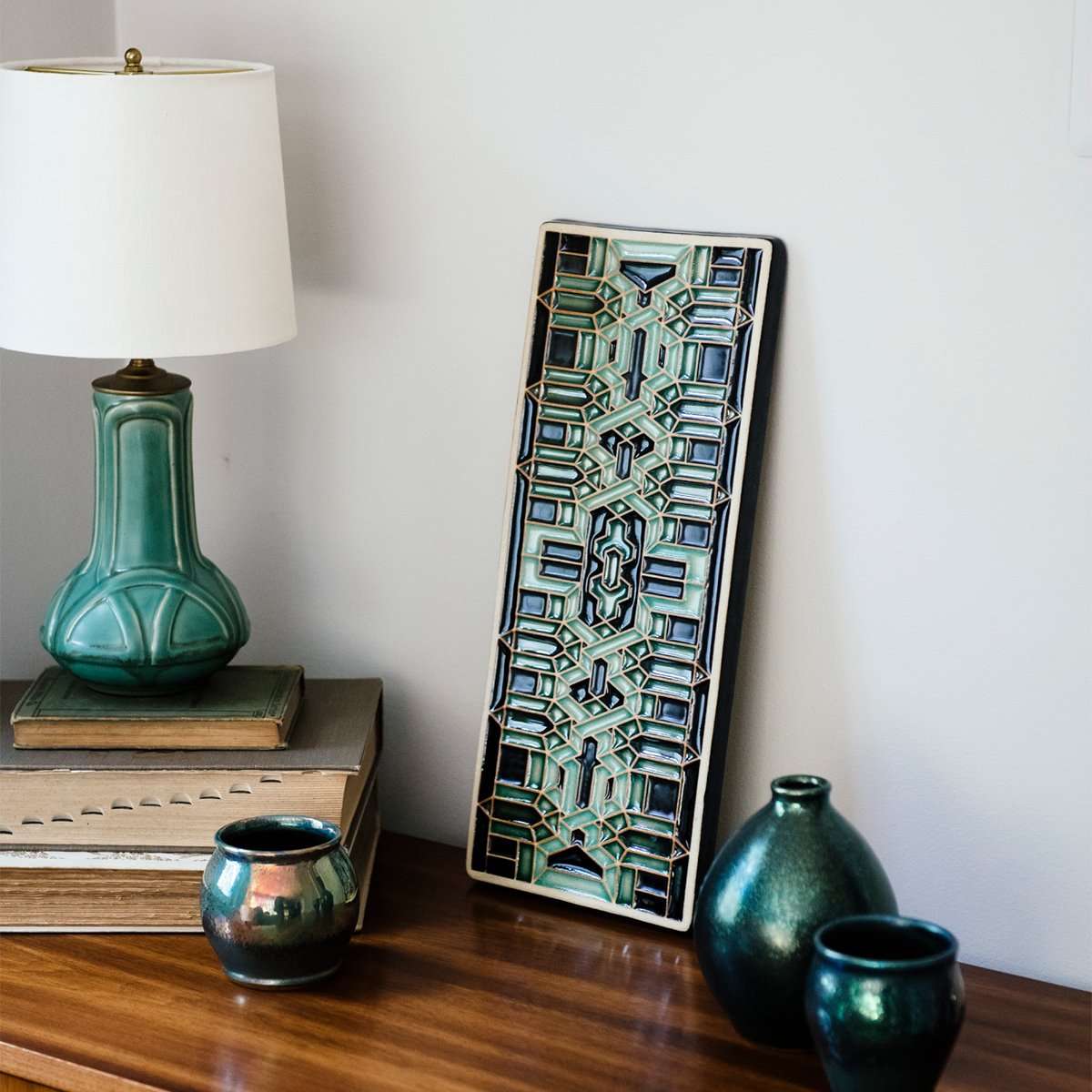 This Guardian Pattern Tile features glaze style B which includes multiple shades of glossy green with black accents.