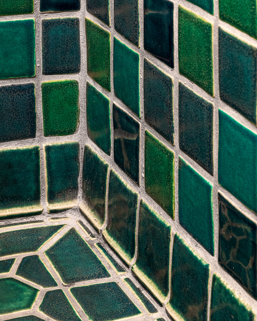 The blue, green, and "Aurora" iridescent 4x4 field tiles and custom trim. A few of the hexagonal and "half-hex" tiles are visible in the frame.