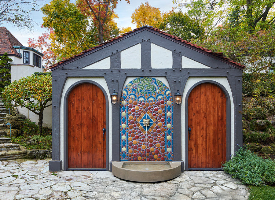 This installation is flat against what looks like a garage with two curved topped wooden doors on either side.