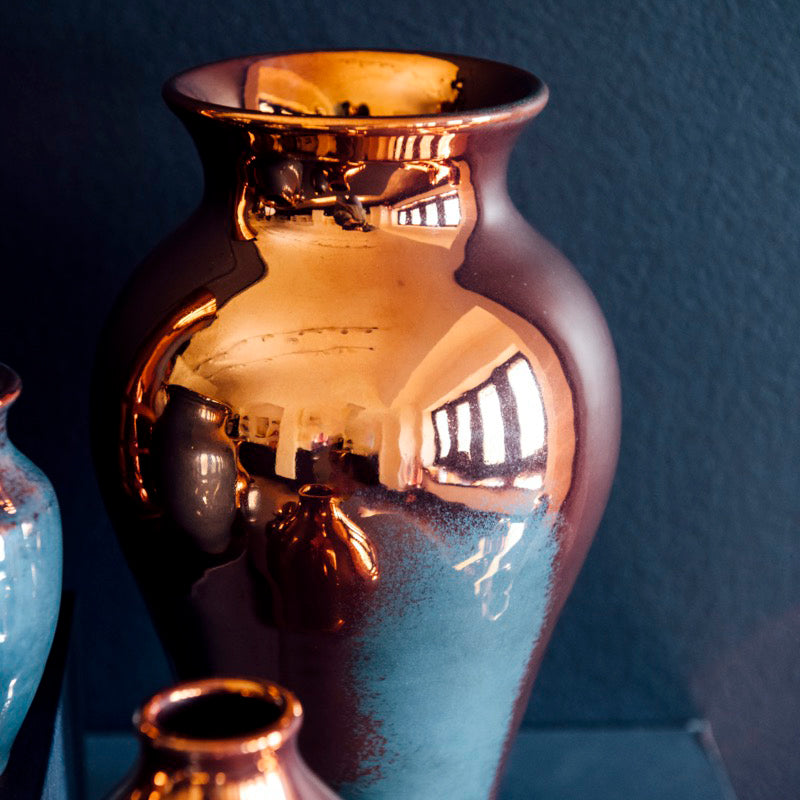 The Copper iridescent glaze is a shiny, smooth metallic glaze with many variations. Some pieces end up with a blue-gray flashing of color that covers a portion of the surface.