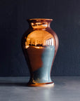 The Large Classic Vase starts with a small diameter at its base that gradually gets larger until it contracts again near the top with a slightly wider lip. The surface of the vase is smooth.
