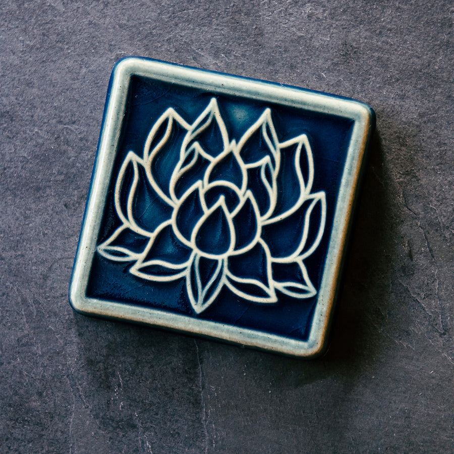 This Lotus Tile features the glossy deep blue Ocean glaze.