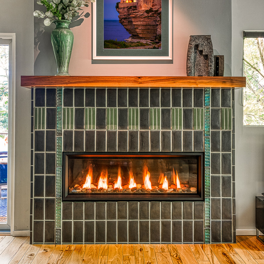 Straight on view of a custom Pewabic fireplace incorporating Midcentury Modern design elements with an Aurora Iridescent Saarinen-inspired tile border.