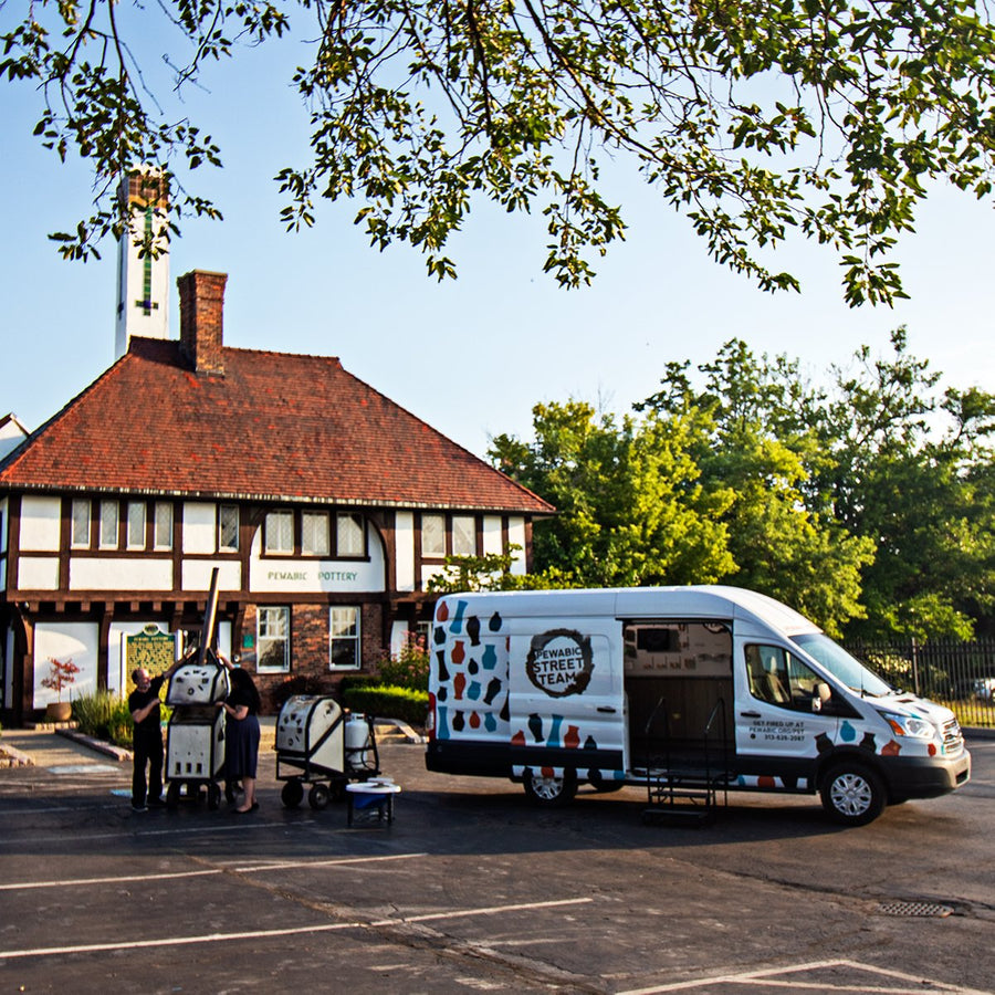 The large Pewabic Street Team van is parked in front of the historic pottery on a warm summer day.