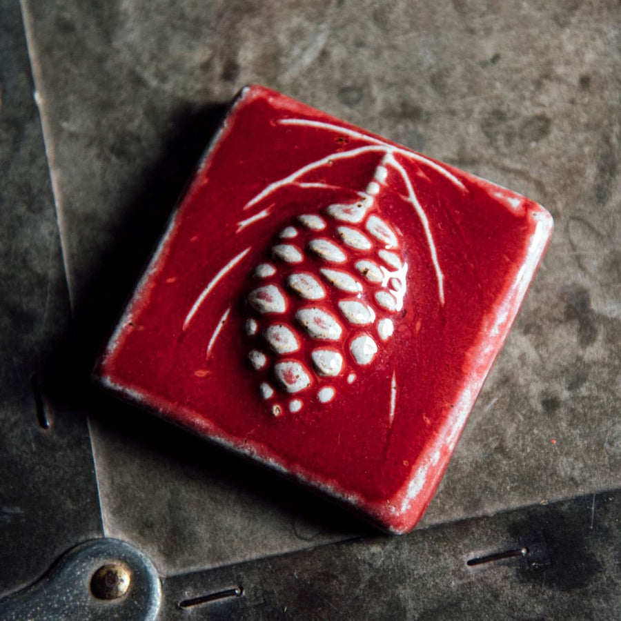This pinecone tile features the deep glossy red Winterberry glaze.