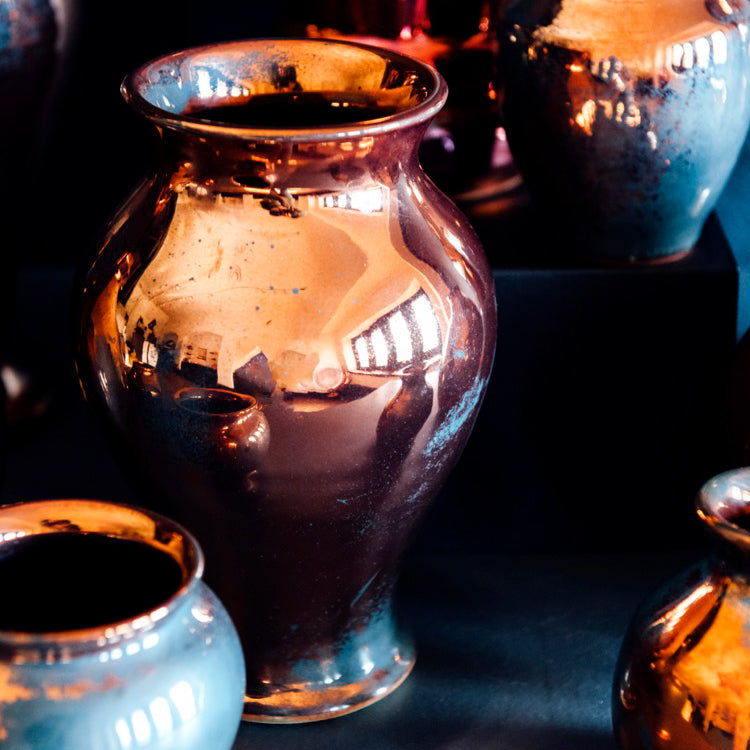 The Copper iridescent glaze is a shiny, smooth metallic glaze with many variations. Some pieces end up with a blue-gray flashing of color that covers a portion of the surface.