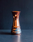 This vase is a sleek, slim vessel. At the base, there are three shallow "steps" with the widest at the bottom. The vase continues up in a smooth column that gets slightly wider at the top.