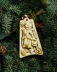 The bell-shaped Eight Maids a-Milking Ornament features a young girl wearing a Bavarian style dress and head scarf. She is carrying a wooden bucket and there are eight small flowers surrounding her. The ornament is glazed in a matte cream glaze.