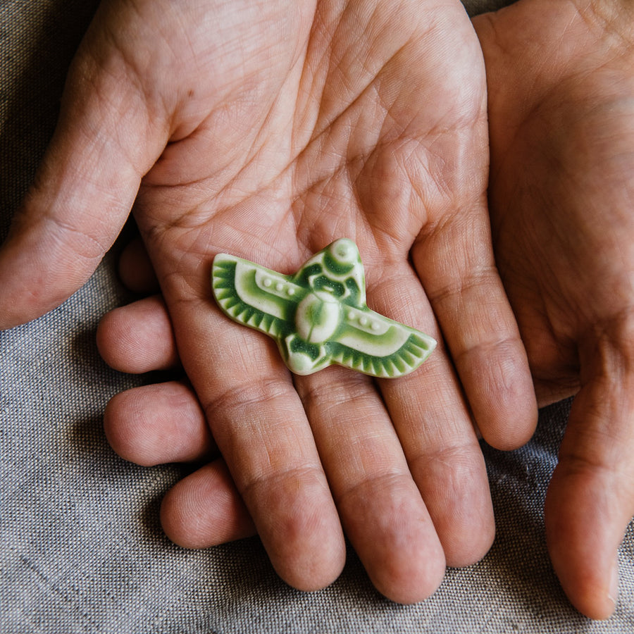 This high relief ceramic pin features a stylized scarab beetle with outstretched wings. The Scarab Pin featured is in our vibrant green-yellow "Lime" glaze.  