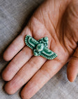 This high relief ceramic pin features a stylized scarab beetle with outstretched wings. The Scarab Pin featured is in our serene jewel-toned green “Pewabic Green” glaze. 