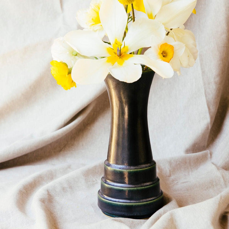 This vase features the satin-finished steel black Gun Metal Glaze . Where the glaze is thinner it gives a green hue.
