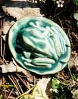 The Frog Paperweight has an oval bottom in the shape of a small lily pad. The high-relief tree frog sits on top- this paperweight is detailed and thick. 