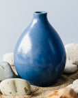 The Teardrop Vase is a very bulbous round vase that contracts quickly to a small opening at the top to place flowers. It is shaped similar to a water balloon filled to the brim and being held by its neck.