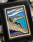 The Hand-painted Sleeping Bear Dunes Tile in a black frame.