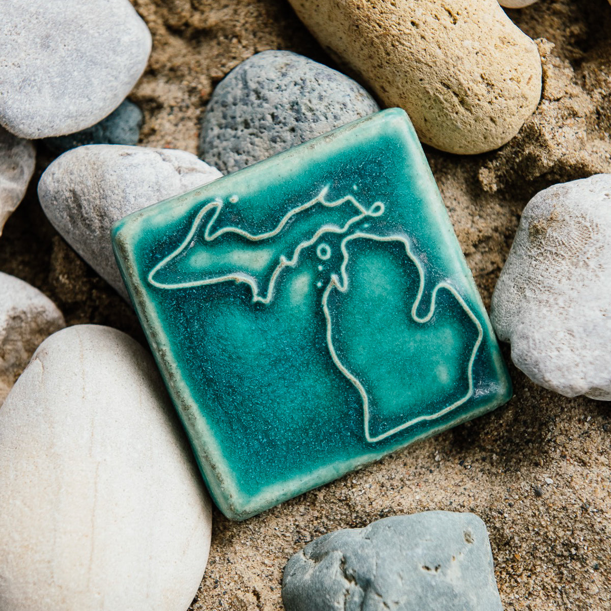 The Michigan Outline Tile features the outline of the state of Michigan with both peninsulas and its larger northern islands. This Michigan Tile features the matte turquoise Pewabic Blue glaze.