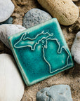 The Michigan Outline Tile features the outline of the state of Michigan with both peninsulas and its larger northern islands. This Michigan Tile features the matte turquoise Pewabic Blue glaze.