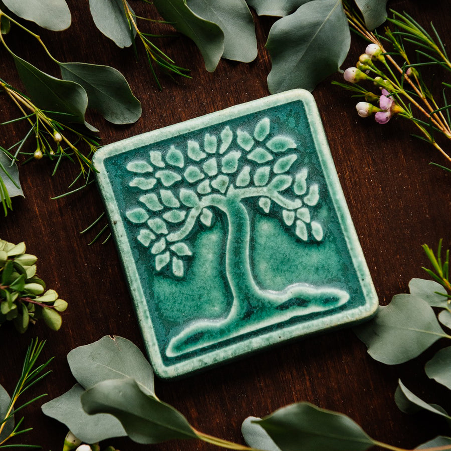 The Botanical Tree tile features a large tree motif with a line border around the tile edge. This ceramic Botanical Tree tile features the matte Pewabic Green glaze.