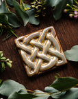 The Journey Knot Tile features two long ovals that create an x pattern with a large ring entwined with them.