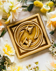 The Daffodil Tile features two flowers entwined in a circle with a strong square border around them.