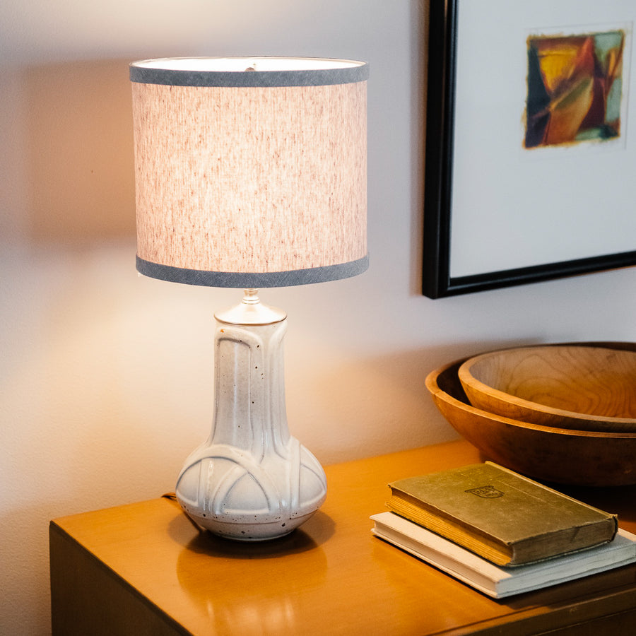The Birch Glazed Lamp is a creamy white with some speckling in shades of brown. The lampshade that comes with the Birch Celtic lamp is a light grey color.