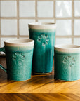 The Pewabic Blue Cafe Mug sits among coordinating Pewabic Blue Pints and Rocks cups.