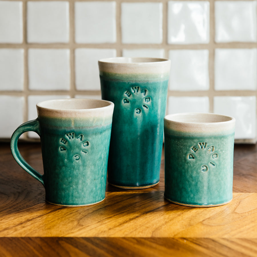 The Pewabic Blue Cafe Mug sits among coordinating Pewabic Blue Pints and Rocks cups.