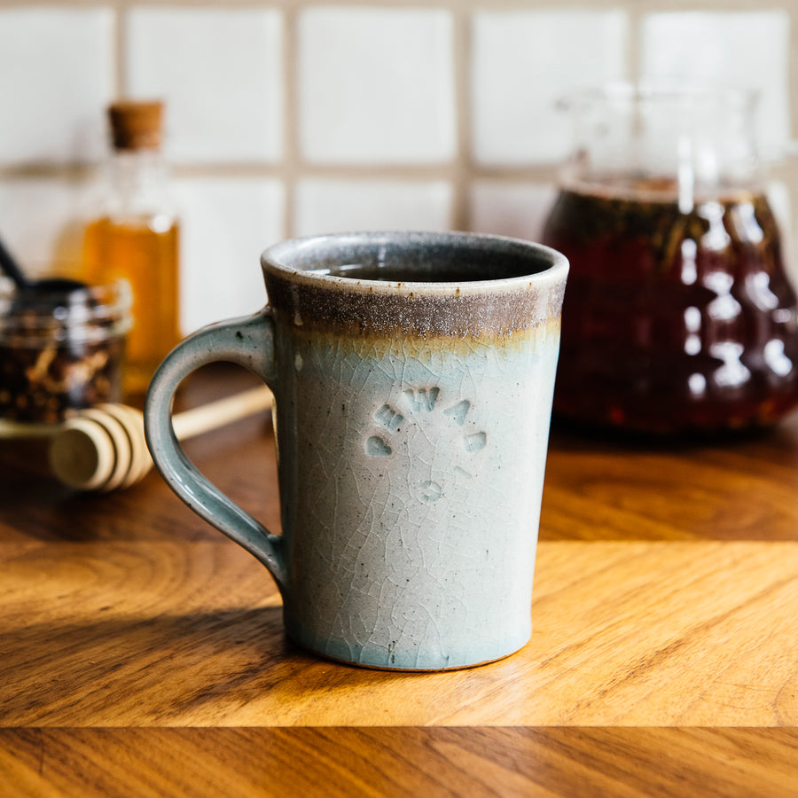 This Cafe Mug has a glossy pale blue Frost glaze with a gray colored interior.