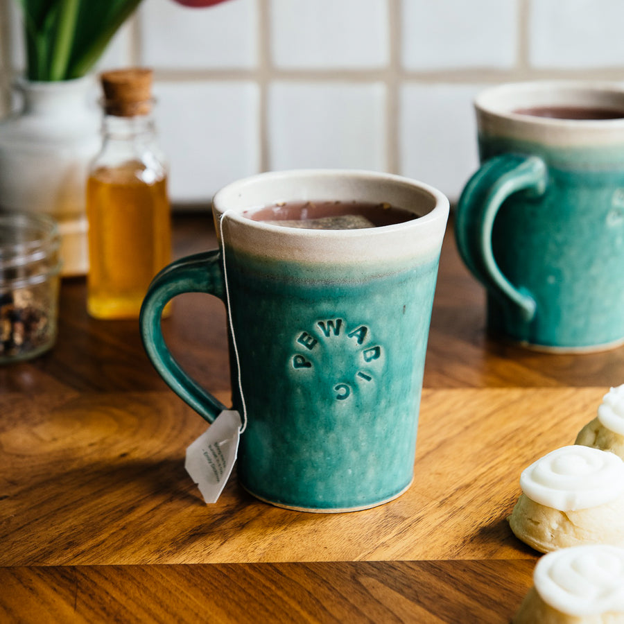 This Cafe Mug has a matte turquoise Pewabic Blue glaze with a cream colored interior.