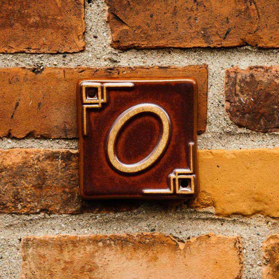 The Craftsman style 0 address number is in the brick reddish brown Carmine Glaze option.