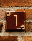 The Craftsman style ceramic 1 address number is in the satin reddish brown Carmine glaze option.