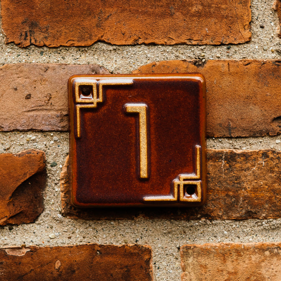 The Craftsman style ceramic 1 address number is in the satin reddish brown Carmine glaze option.