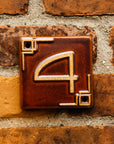 The Craftsman style ceramic 4 address number is in the satin reddish brown Carmine glaze option.