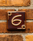 The Craftsman style ceramic 6 address number is in the satin reddish brown Carmine glaze option.