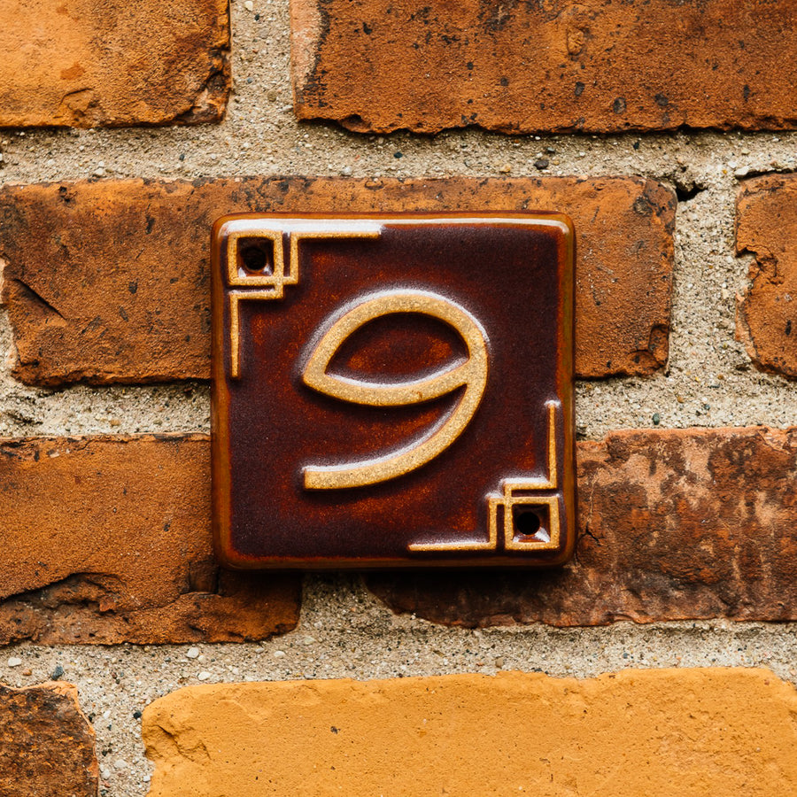 The Craftsman style ceramic 9 address number is in the satin reddish brown Carmine glaze option.