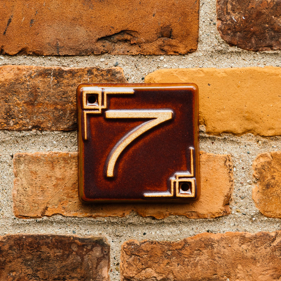 The Craftsman style ceramic 7 address number is in the satin reddish brown Carmine glaze option.