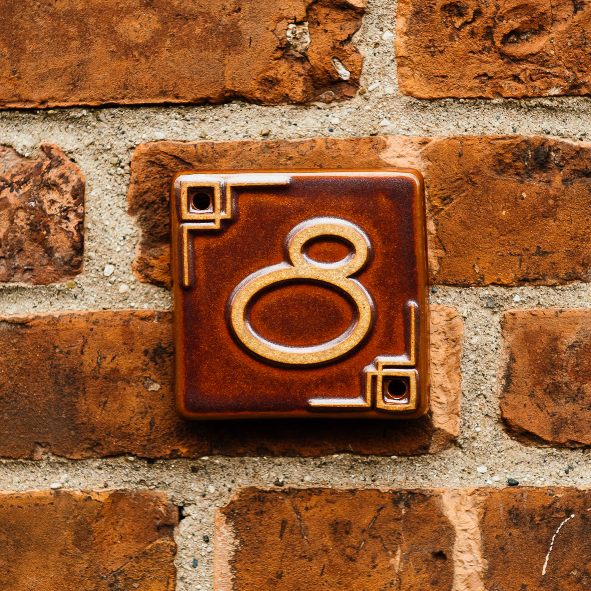 The Craftsman style ceramic 8 address number is in the satin reddish brown Carmine glaze option.