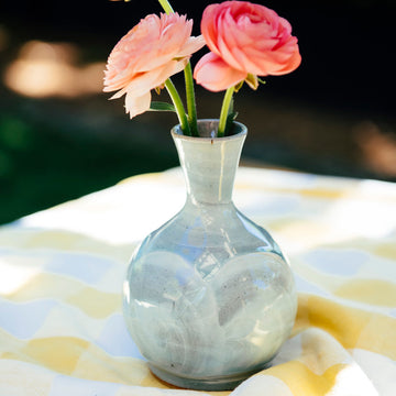 The Bud Vase has a bulbous shape, mimicking the roundness of a flower bud, with slip added to the sides by hand to create a petal-like appearance. From the round bottom emerges an organic tall opening at the top to keep your flowers straight up. 