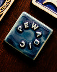 The small square Pewabic logo tile features the word "Pewabic" written in a circle.
