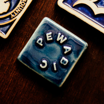 The small square Pewabic logo tile features the word "Pewabic" written in a circle.