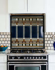 The Wright Backsplash features an intricate geometric design harkening to Frank Lloyd Wright's mid-century design. The tiles feature multiple blue shades with details in grays, browns and white. 