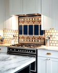 The detailed portions of the backsplash are contained behind the brushed silver stove with modern white cabinets.