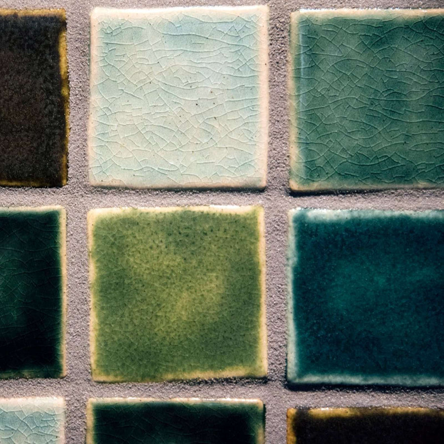 A detail of four tiles show that some are matte colors and others are glossy with crazing.