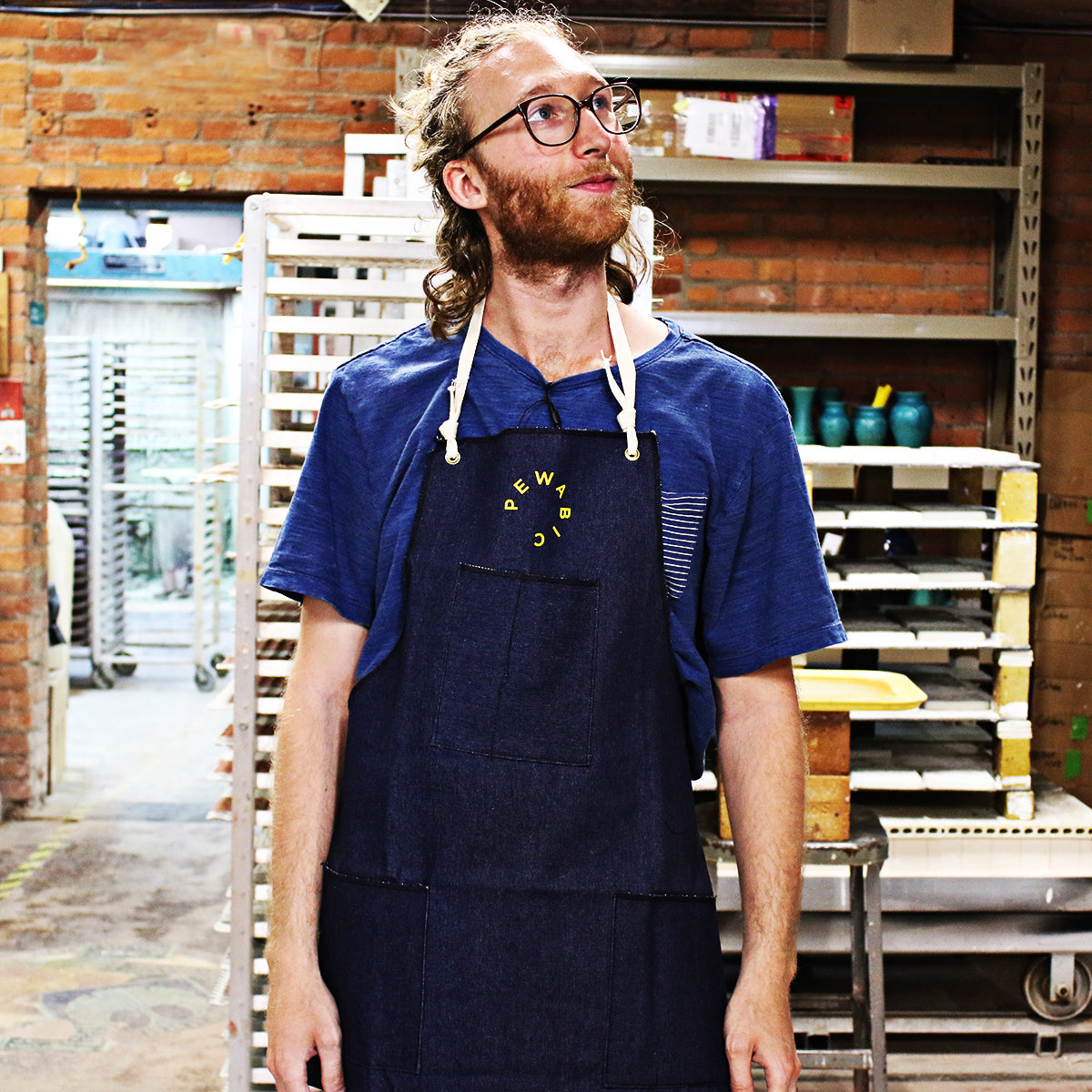 Shown on a Pewabic artisan in the kiln room of Pewabic, this apron has a solid rope around the back of the neck of the wearer.