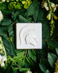 The Spartan Tile features a high relief design of a Spartan helmet with a large crest. 