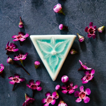 This inverted triangle shaped pin features a delicately sculpted three petaled trillium flower. The pin comes in our glossy pale blue Celadon glaze.