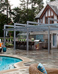 A view of an outdoor kitchen, bar, and tiled backsplash that match the custom fountain in a range of blue and green colored glazes.