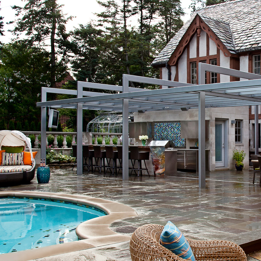 A view of an outdoor kitchen, bar, and tiled backsplash that match the custom fountain in a range of blue and green colored glazes.