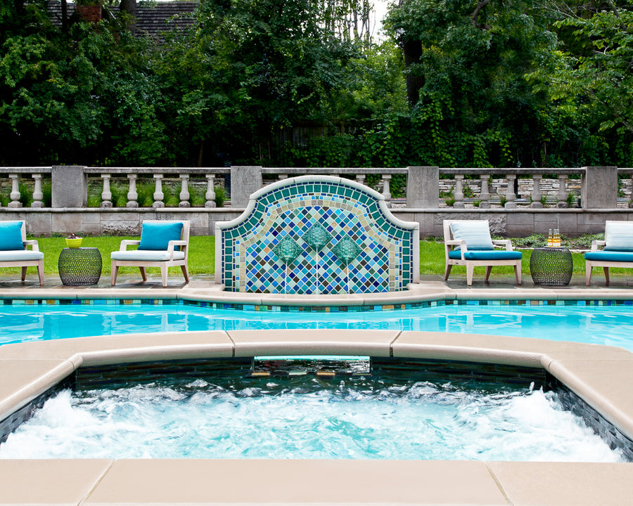 Outdoor poolside fountain in a range of glaze colors that look like the colorful plumes of a peacock. There are three hand-sculpted turtle sculptures at the center of the design in a blue-green glaze.