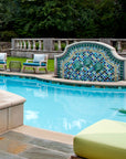 Outdoor poolside fountain in a range of glaze colors that look like the colorful plumes of a peacock. There are three hand-sculpted turtle sculptures at the center of the design in a blue-green glaze.