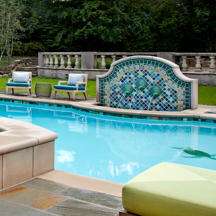 Outdoor poolside fountain in a range of glaze colors that look like the colorful plumes of a peacock. There are three hand-sculpted turtle sculptures at the center of the design in a blue-green glaze.